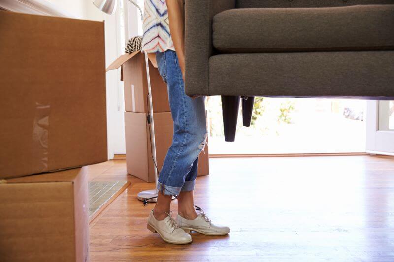 Close up of woman carrying sofa on wood flooring image