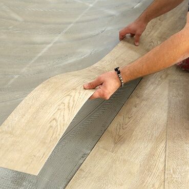 Worker installing new vinyl tile floor