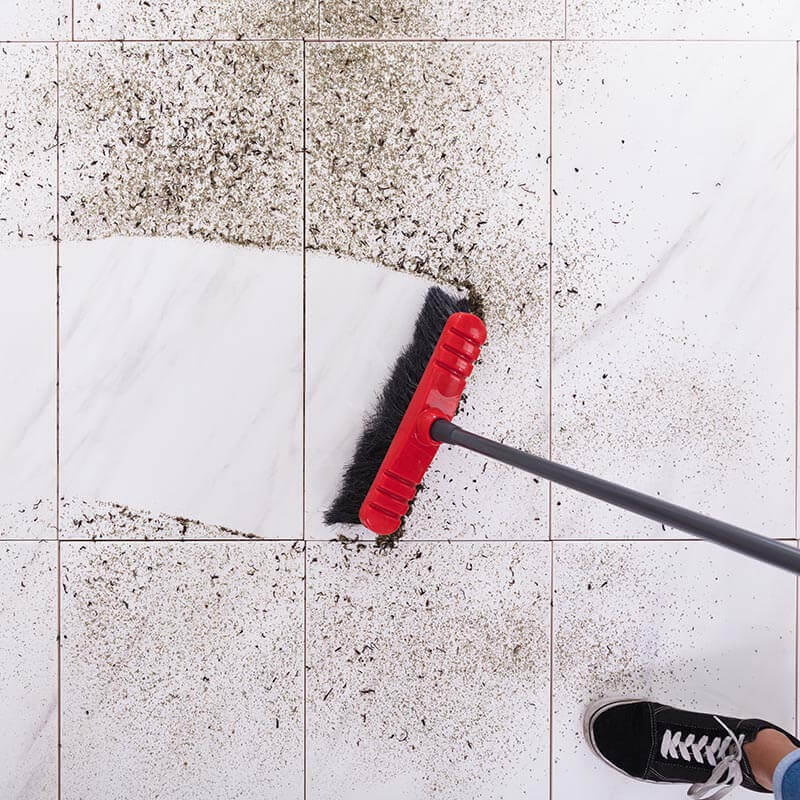 sweeping mess off of tile floor with broom